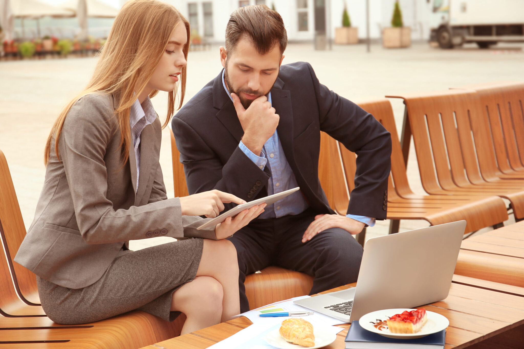 Young marketing managers working in cafe outdoors